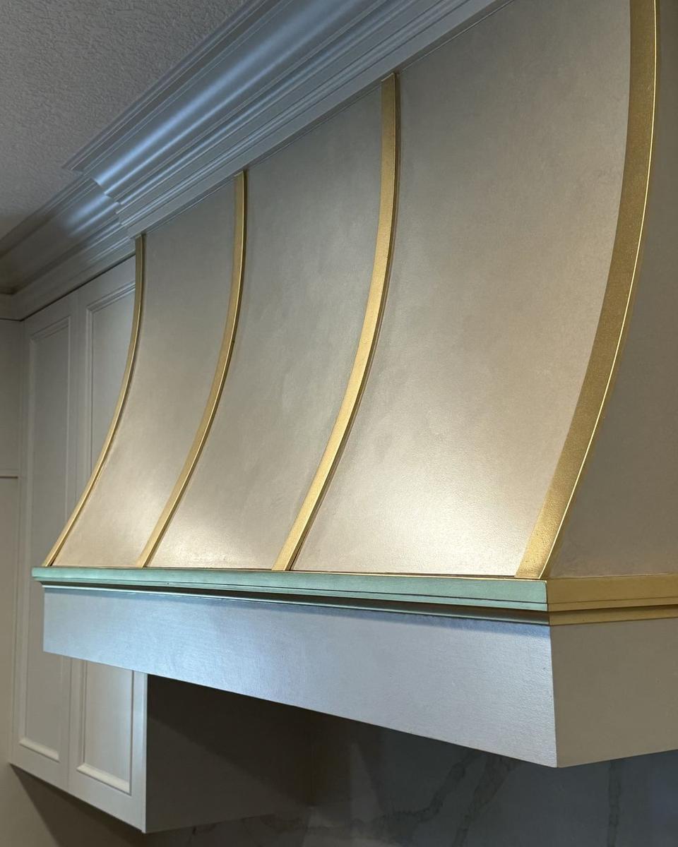 Curved brass-striped kitchen range hood