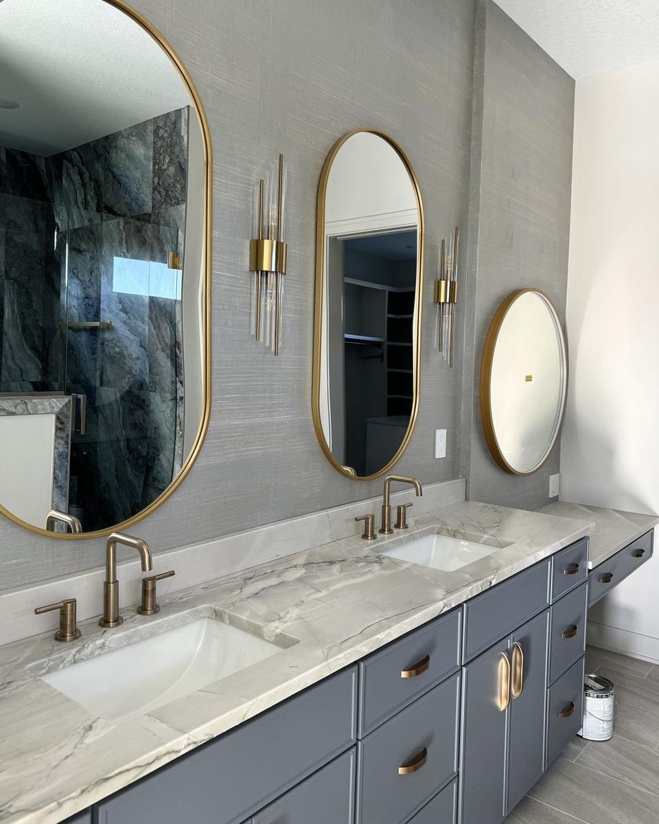 Double vanity bathroom with oval brass mirrors