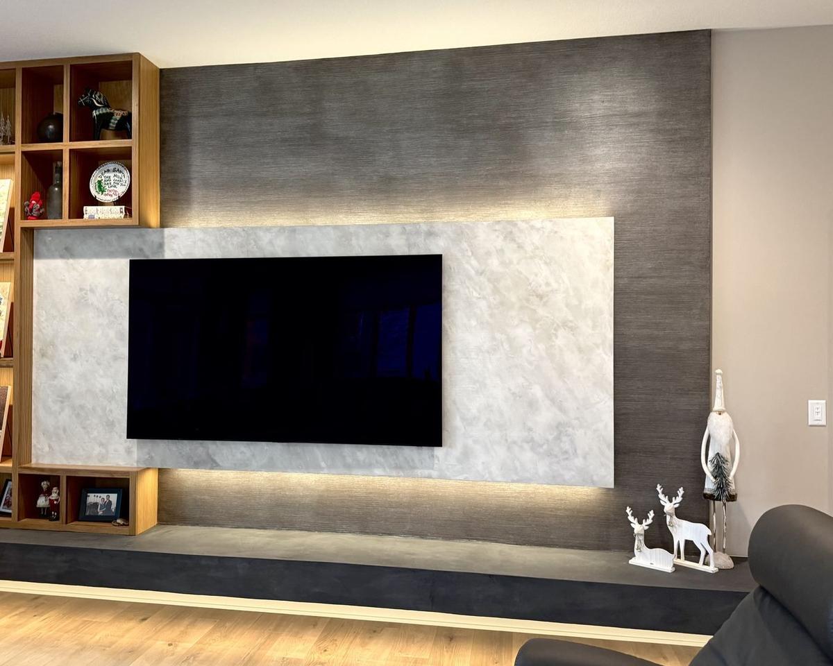 Plaster accent wall with stacked stone fireplace